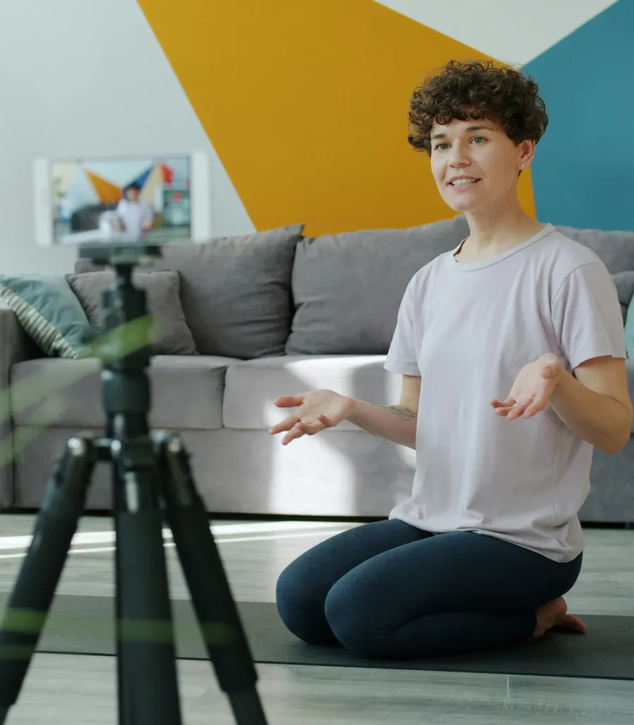 Creator recording a video on a phone mounted on a tripod at home