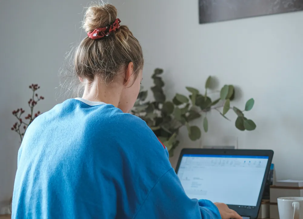 Entrepreneur managing client orders on a laptop in a home office
